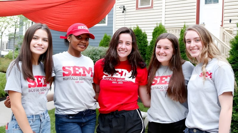 Eine Gruppe von fünf Schülerinnen und Schülern der Buffalo Seminary steht vor einem Wohnhaus mit rotem Vordach.