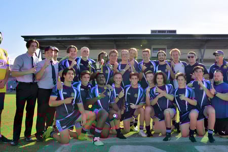 Eine Gruppe von Schülerinnen und Schülern des Bundaberg State High School posiert vor einem Gebäude mit einem farbenfrohen Wandbild.