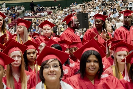 Absolventinnen und Absolventen der Burnie High School stehen in roten Talaren zusammen bei einer Abschlussfeier.