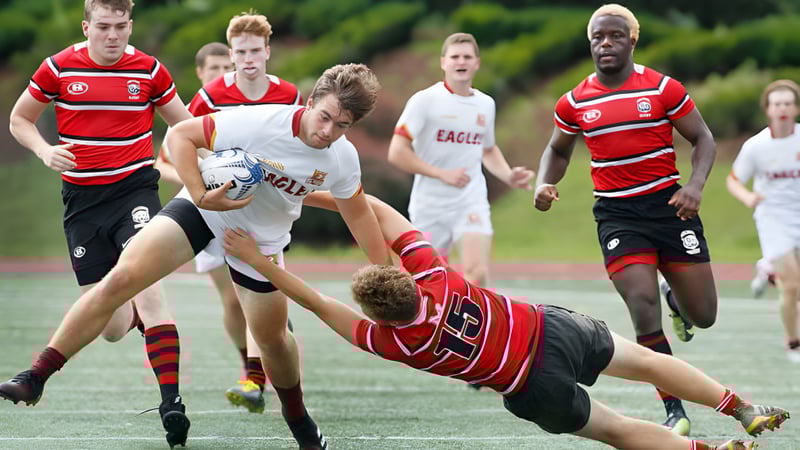 Schüler der Burnie High School spielen ein Rugby-Match auf dem Sportfeld mit Spielern in roten und weißen Trikots.