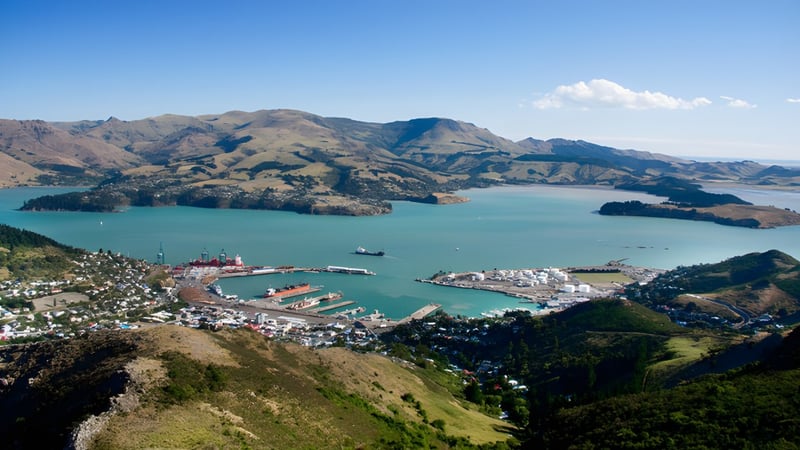 Der Hafen einer Küstenstadt mit Bergen und türkisfarbenem Wasser im Hintergrund, in der Nähe von Burnside High School.