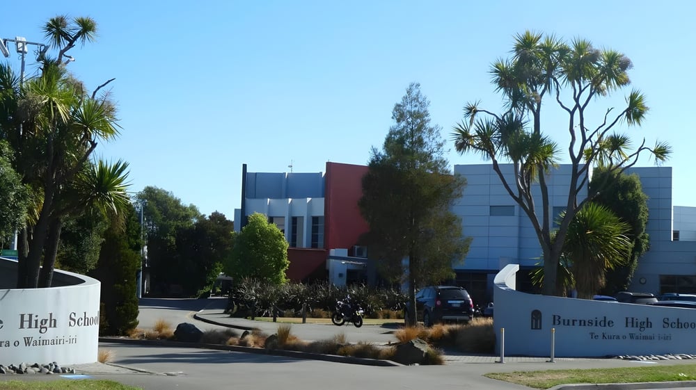 Der Campus der Burnside State High School mit Palmen und einem modernen mehrstöckigen Gebäude im Hintergrund.