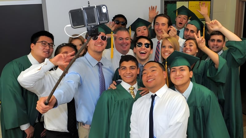 Eine Gruppe von Schülern der Burnside State High School feiert gemeinsam ihren Abschluss in Abschlussrobe.