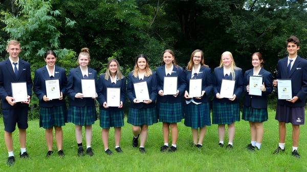 Eine Gruppe von Schülerinnen und Schülern der Burnside State High School steht im Freien und hält Zertifikate in der Hand.