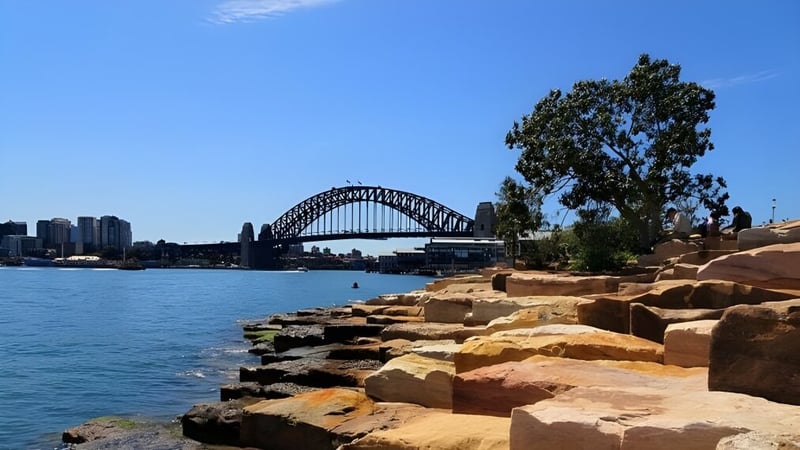 Blick auf die Sydney Harbour Bridge mit felsigem Vordergrund und blauem Himmel, nicht direkt mit Burpengary State Secondary College verbunden.