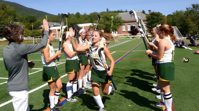 Eine Gruppe junger Athletinnen trägt Sportuniformen auf dem Sportfeld der Burr and Burton Academy.