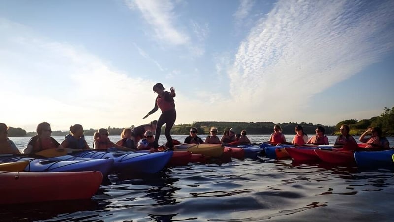 Schüler der Bush Post Primary School beim gemeinsamen Rafting auf einem Gewässer unter bewölktem Himmel.