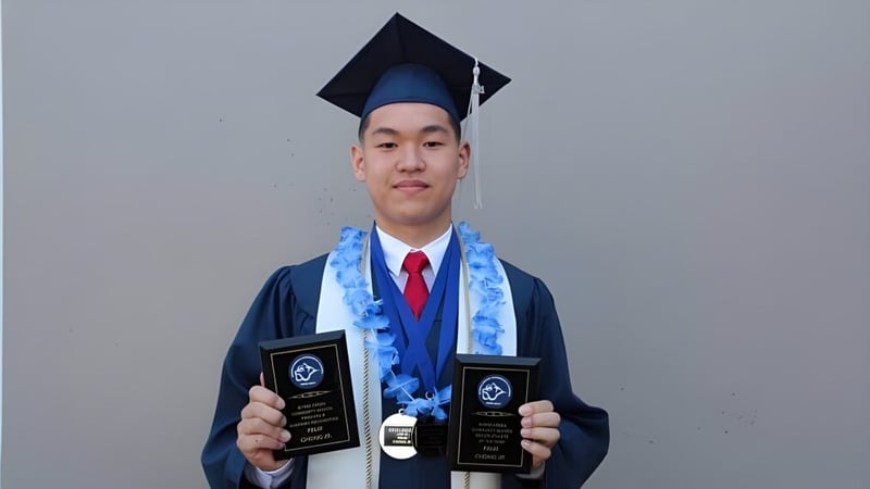 Ein Absolvent der Byrne Creek School steht vor grauem Hintergrund und hält zwei Auszeichnungen in den Händen.