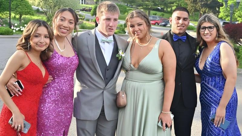 Eine Gruppe von Schülerinnen und Schülern der Cabinteely Community School steht im Freien vor Bäumen und Gebäuden.