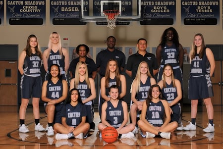 Eine Gruppe junger Basketballspielerinnen posiert in der Sporthalle der Cactus Shadows High School.