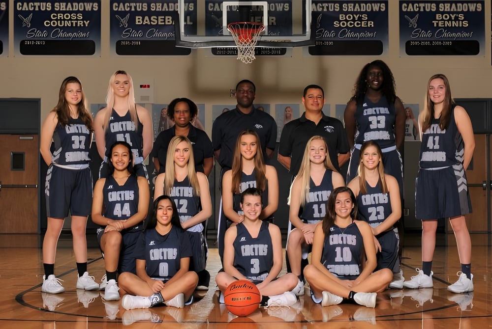 Eine Gruppe junger Basketballspielerinnen posiert in der Sporthalle der Cactus Shadows High School.