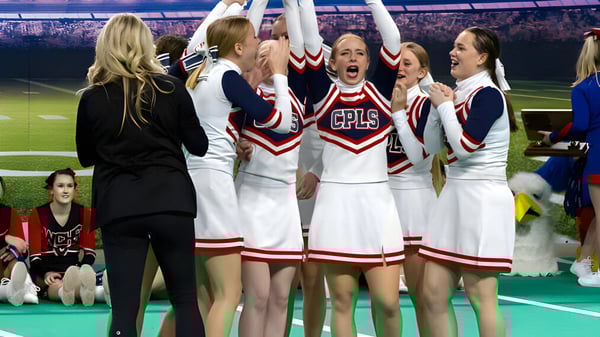 Cheerleader der Cair Paravel Latin School feiern auf dem Sportfeld vor einer grossen Menschenmenge.