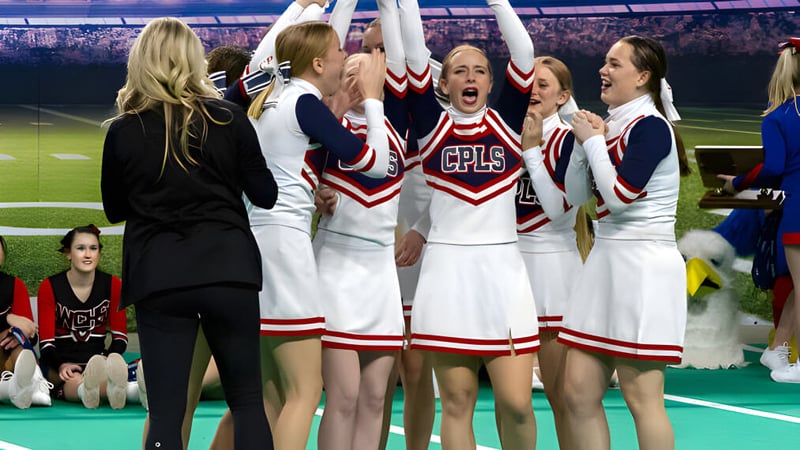 Cheerleader der Cair Paravel Latin School feiern auf dem Sportfeld vor einer grossen Menschenmenge.