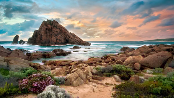 Eine felsige Küstenlandschaft mit Klippen und Wellen bei Sonnenuntergang nahe dem Calamvale Community College.