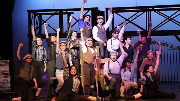 Eine Gruppe von Schülerinnen und Schülern der Caledonia Secondary School steht auf der Bühne bei einer Theateraufführung.