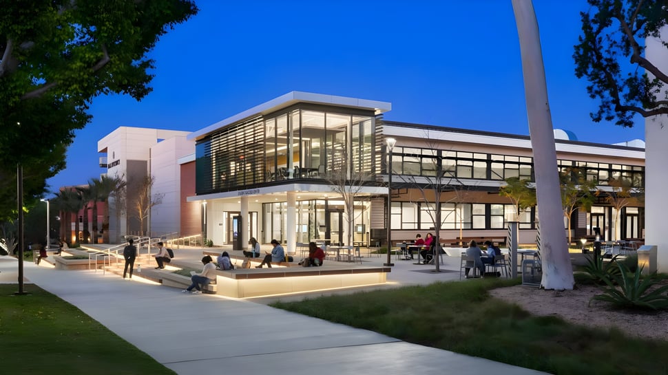 Das moderne Glasgebäude mit Sitzbereich auf dem Campus der California State University Long Beach bei klarem Himmel.