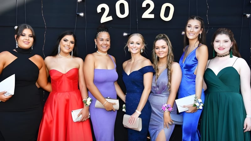 Sechs Schülerinnen des Caloundra Christian College posieren vor einem Hintergrund mit der Jahreszahl 2020 beim Abschlussball.