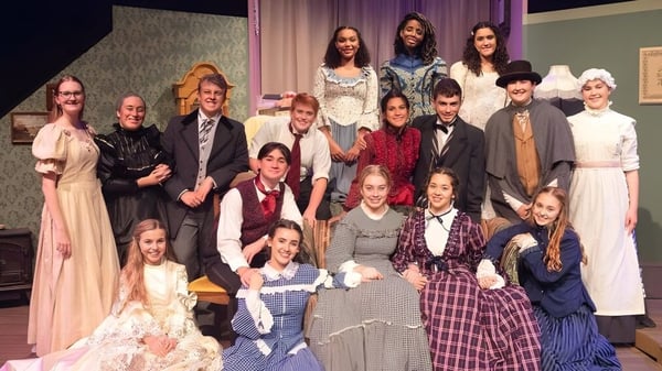 Schüler der Calvary Christian Academy posieren gemeinsam in historischen Kostümen auf einer Bühne mit Vorhang und Kulisse.