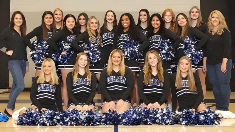 Eine Gruppe von Cheerleaderinnen der Calvary Day School posiert in einheitlichen Uniformen vor neutralem Hintergrund.