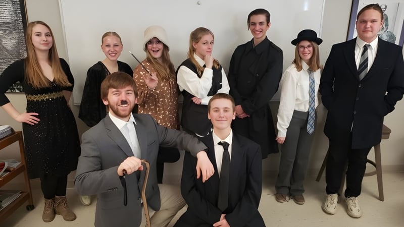 Eine Gruppe von Schülerinnen und Schülern der Cambridge Christian School steht gemeinsam vor einer weißen Wand in einem formellen Rahmen.