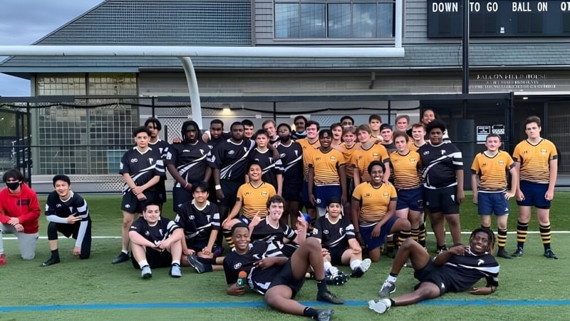 Eine Gruppe von Schülern der Cambridge Rindge and Latin High School posiert als Sportmannschaft auf einem Rasen vor einem Gebäude.
