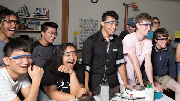 Eine Gruppe Schüler der Cambridge School of Weston lacht gemeinsam in einer informellen Umgebung.