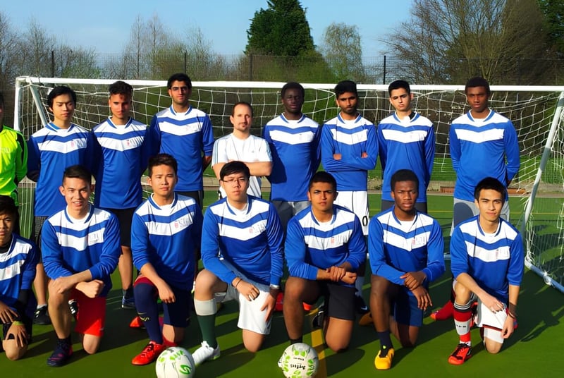 Eine Gruppe von Schülerinnen und Schülern des Cambridge Tutors College steht vor einem Fußballtor auf einem Rasenplatz.