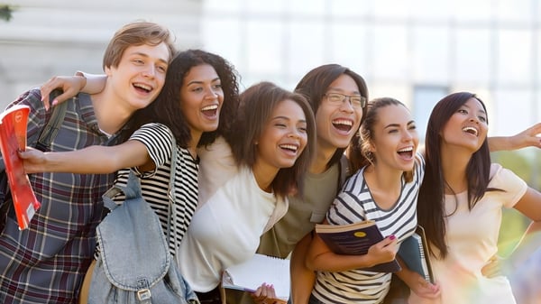 Eine Gruppe von Schülerinnen des Cambridge Tutors College umarmt sich lachend im Freien.
