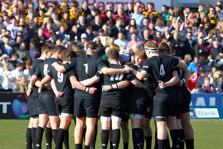 Eine Gruppe von Fußballspielern des Campbell College steht gemeinsam auf dem Spielfeld vor einer großen Zuschauermenge.