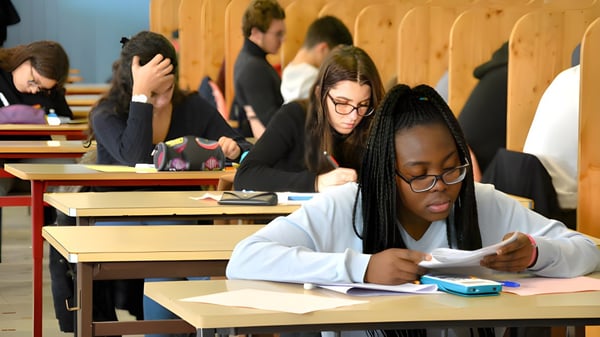 Schüler im Klassenzimmer des Campus La Salle Saint Christophe schreiben, arbeiten mit elektronischen Geräten oder unterhalten sich.