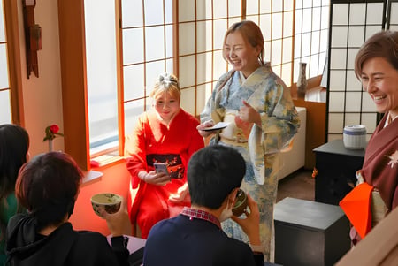 Schüler der Canadian Academy tragen traditionelle japanische Kleidung in einem Raum mit japanischem Dekor.