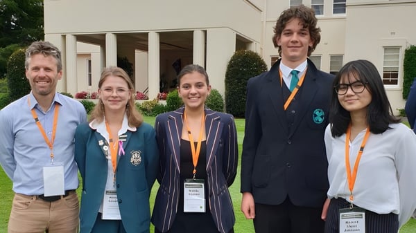 Fünf Schüler stehen vor einem Gebäude mit Veranda und Garten auf dem Campus des Canberra College.