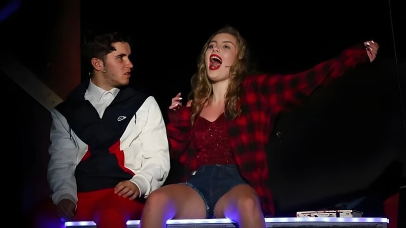 Eine Schülerin singt auf der Bühne während ein Schüler neben ihr steht auf dem Campus der Canterbury Academy.