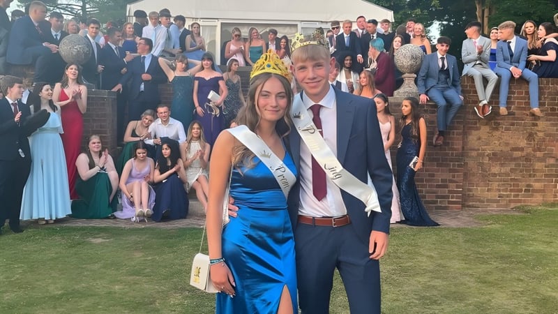 Eine Gruppe von Menschen in formeller Kleidung posiert im Freien für ein Gruppenfoto auf dem Campus der Canterbury Academy.