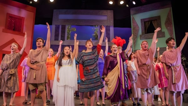 Schüler der Canterbury School führen auf der Bühne in farbenfrohen Kostümen eine dynamische Performance auf.