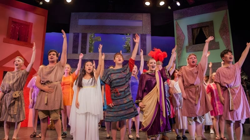 Schüler der Canterbury School führen auf der Bühne in farbenfrohen Kostümen eine dynamische Performance auf.