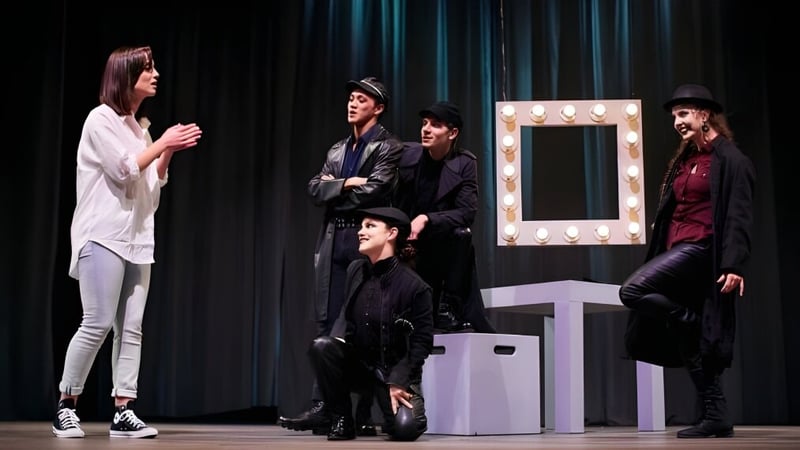 Eine Gruppe von Personen steht auf der Bühne mit einem beleuchteten Rahmen im Hintergrund auf dem Campus der Capilano University.
