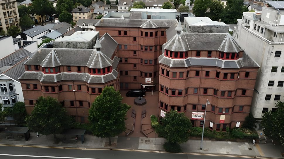Das Cardiff Sixth Form College zeigt ein Ensemble aus roten Backsteingebäuden mit Türmen und begrüntem Umfeld.