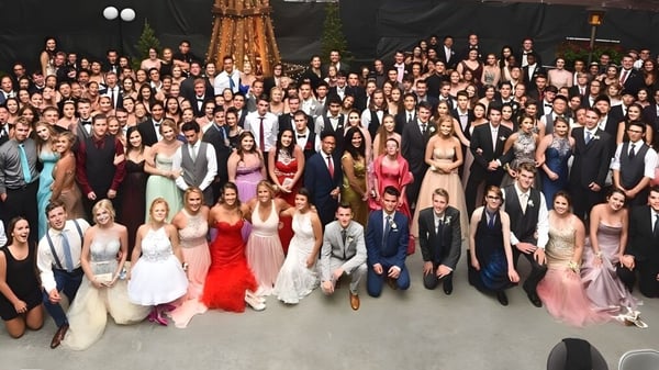 Schüler der Carihi Secondary School versammeln sich bei einem formellen Anlass in einem eleganten Raum mit Kronleuchter.