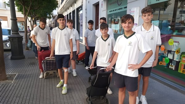 Eine Gruppe Schüler steht auf der Straße vor Geschäften auf dem Gelände der Carmelitas Cadiz Colegio.