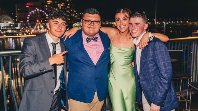 Vier Personen posieren in festlicher Umgebung vor der Stadtsilhouette auf dem Campus der Carrigallen Vocational School.