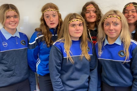 Eine Gruppe Schüler der Carrigallen Vocational School trägt blaue Uniformen und posiert gemeinsam mit verschiedenen Gesichtsausdrücken.