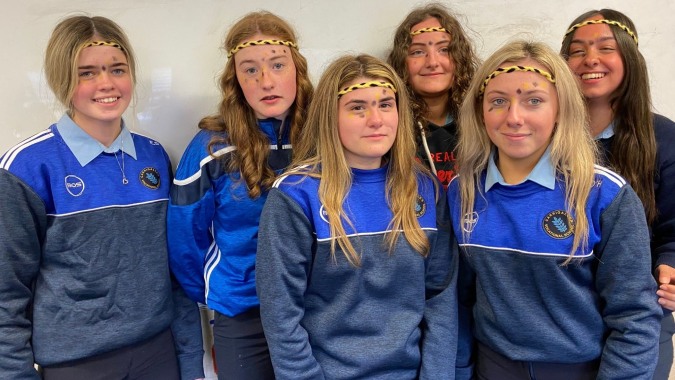 Eine Gruppe von Schülerinnen und Schülern der Carrigallen Vocational School posiert in blauen Uniformen und Stirnbändern gemeinsam.