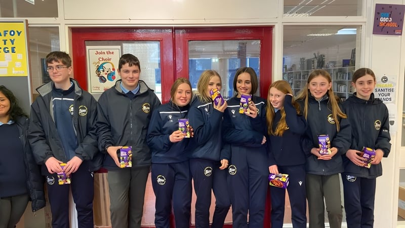 Schüler des Carrignafoy Community College stehen gemeinsam im Schulflur mit einheitlicher Schuluniform.