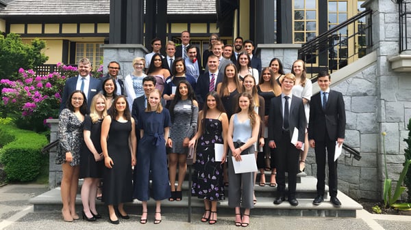 Eine Gruppe von Schülerinnen und Schülern steht gemeinsam auf der Treppe eines historischen Gebäudes auf dem Campus der Carson Graham Secondary School.