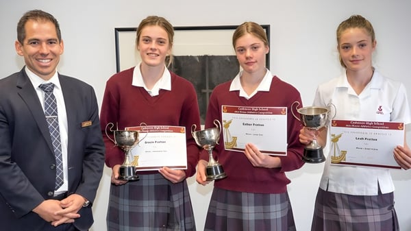 Vier Schülerinnen und Schüler der Cashmere High School präsentieren stolz ihre Auszeichnungen und Trophäen.