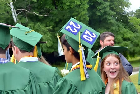 Eine Gruppe von Absolventen in grünen Talaren steht im Freien auf dem Campus des Castleblayney College.