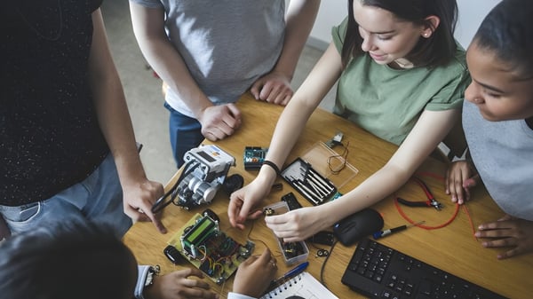 Schülerinnen und Schüler des Castlepollard Community College arbeiten gemeinsam an einem Elektronikprojekt mit verschiedenen Bauteilen.