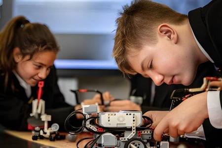 Zwei Schüler der Caterham School arbeiten konzentriert an einem elektronischen Bauteil im Unterricht.
