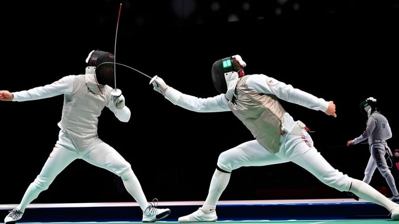 Zwei Schüler der Cathedral School of St Anne & St James im Fechtwettkampf vor dunklem Hintergrund.